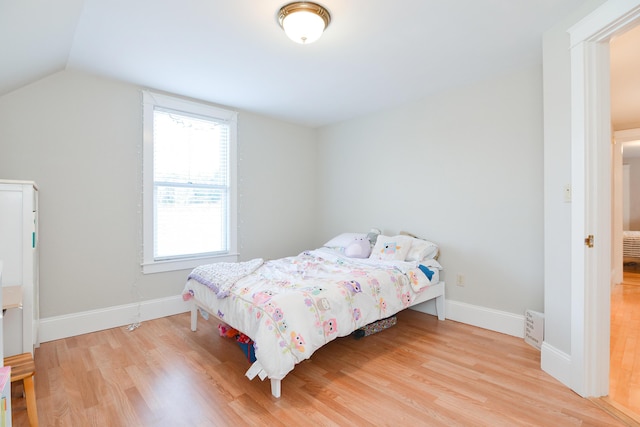 bedroom with lofted ceiling and light wood-type flooring