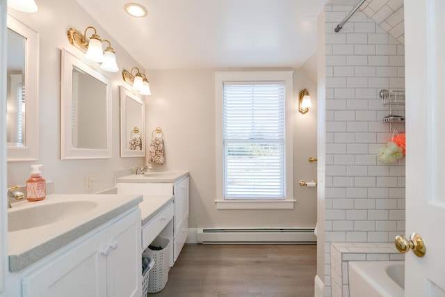 bathroom with hardwood / wood-style floors, baseboard heating, vanity, and plenty of natural light