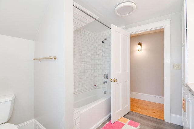 bathroom featuring tiled shower / bath, toilet, and hardwood / wood-style flooring