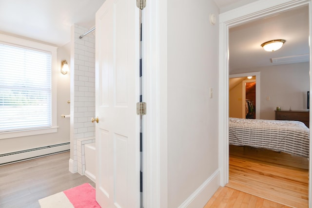 corridor featuring a baseboard radiator and light hardwood / wood-style floors