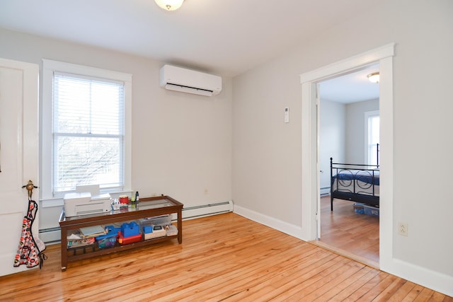 interior space featuring light wood-type flooring, a wall mounted air conditioner, and a baseboard heating unit