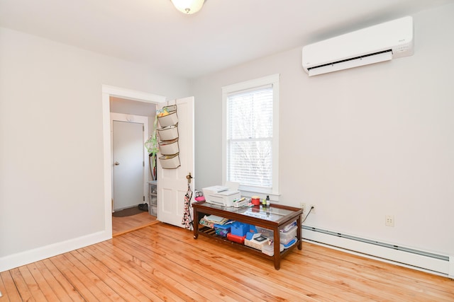 interior space featuring a wall unit AC, baseboard heating, and light hardwood / wood-style flooring