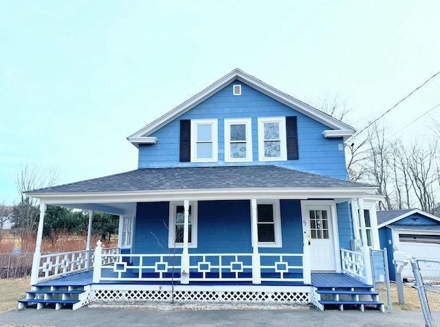 farmhouse with covered porch, a garage, and an outdoor structure