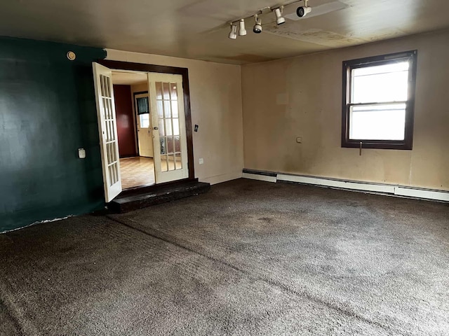 carpeted spare room with baseboard heating, french doors, and track lighting