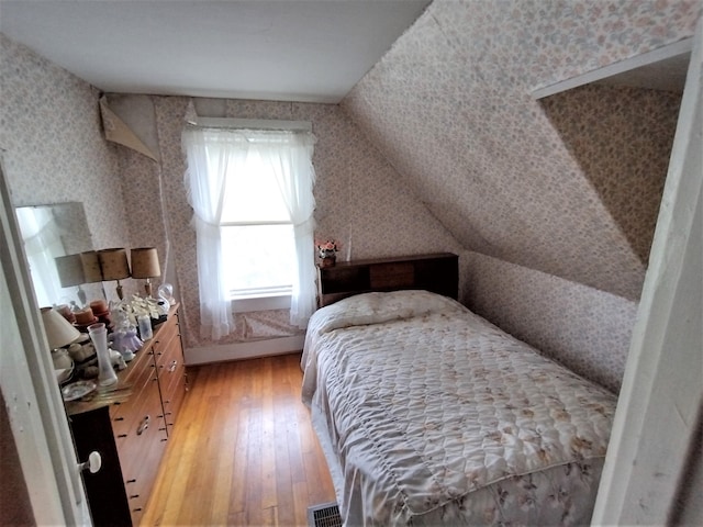 bedroom featuring hardwood / wood-style flooring and vaulted ceiling