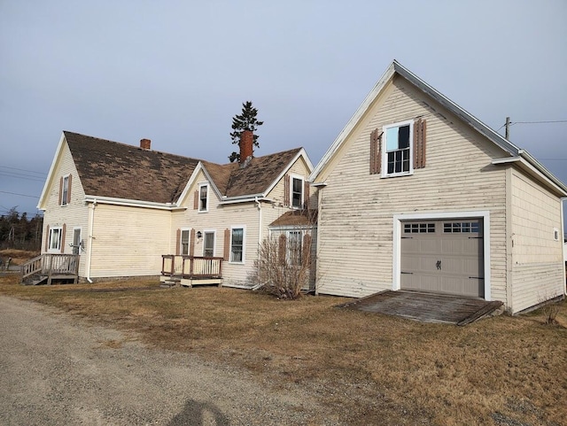 exterior space featuring a garage and a lawn