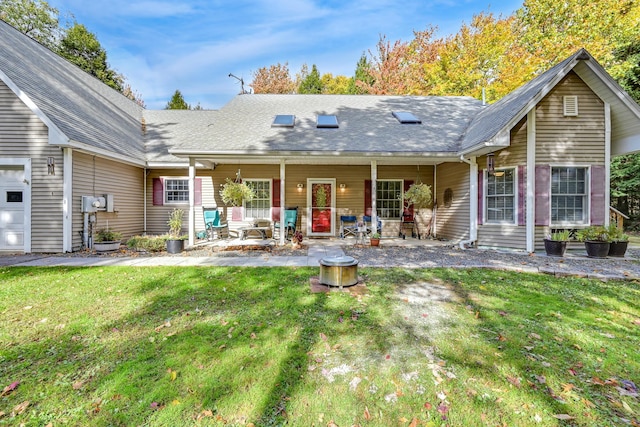 rear view of house with a lawn and a porch