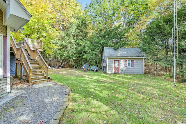 view of yard featuring an outdoor structure and a deck