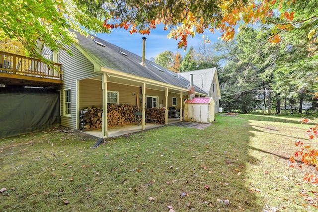 exterior space featuring a wooden deck, a patio area, a yard, and a storage unit