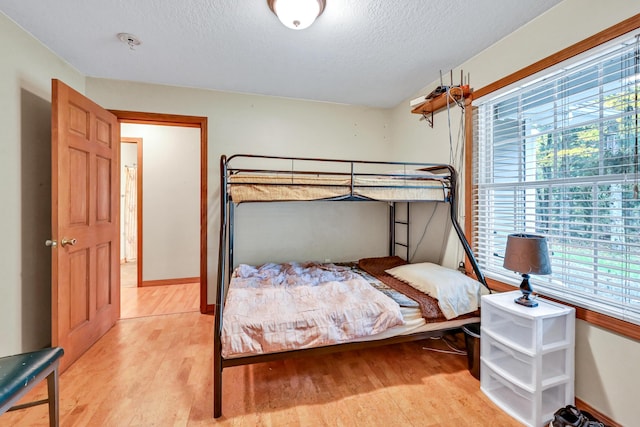 bedroom featuring light wood-type flooring and a textured ceiling