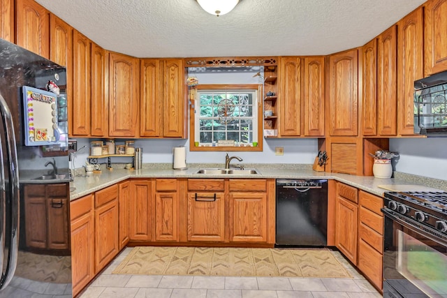 kitchen with black appliances, light tile patterned floors, sink, and a textured ceiling