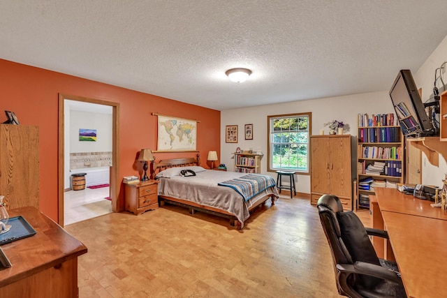 bedroom featuring ensuite bath and a textured ceiling