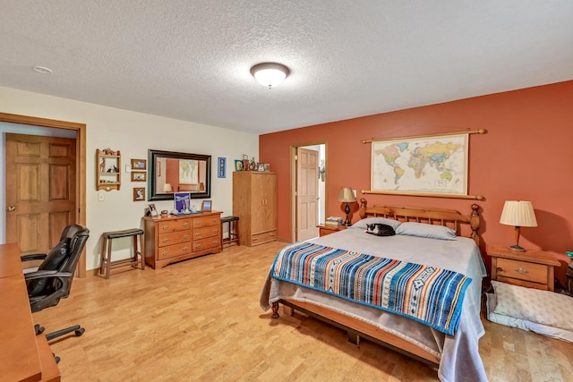 bedroom with hardwood / wood-style floors and a textured ceiling