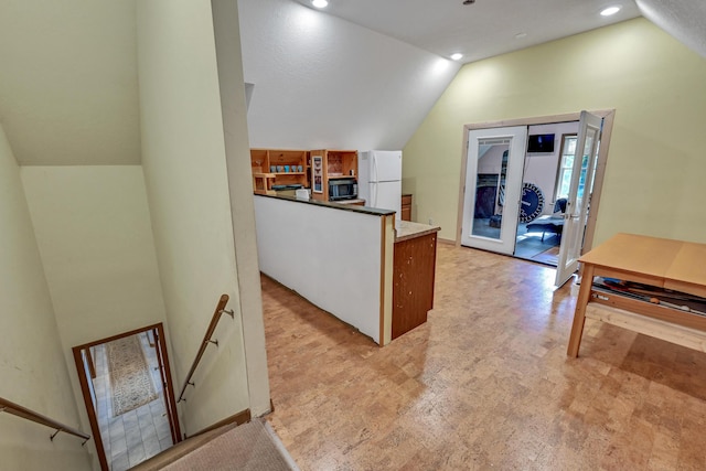 kitchen featuring white fridge, vaulted ceiling, and french doors