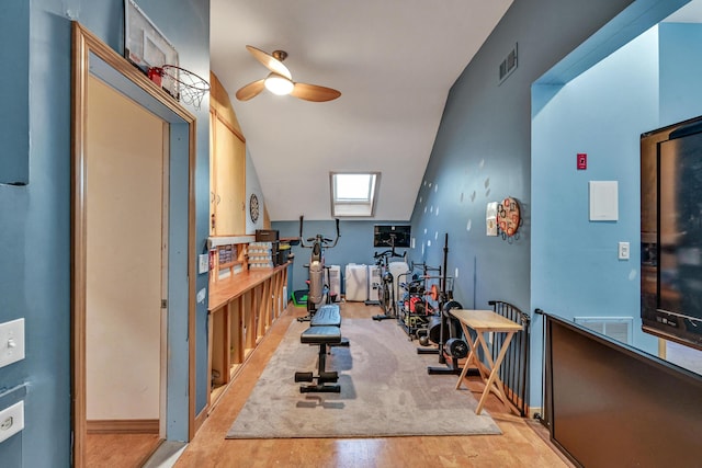 exercise room featuring light wood-type flooring, ceiling fan, and lofted ceiling