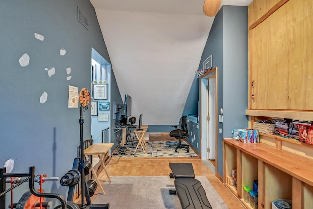 workout room featuring light colored carpet and vaulted ceiling