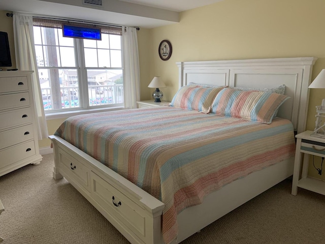 bedroom featuring light colored carpet and multiple windows