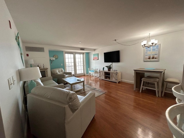 living room featuring french doors, dark hardwood / wood-style floors, and an inviting chandelier