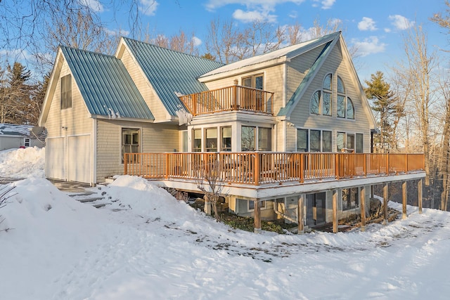 snow covered property featuring a balcony and a deck