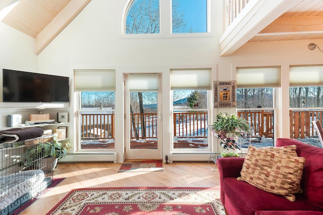 living room featuring beam ceiling, light wood-type flooring, a baseboard radiator, and wooden ceiling