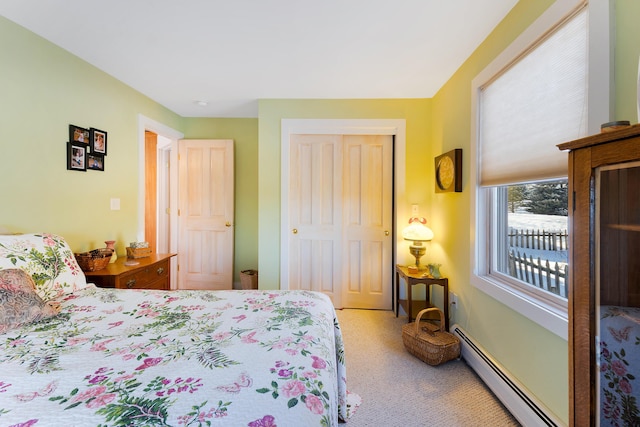 carpeted bedroom with a closet and a baseboard heating unit