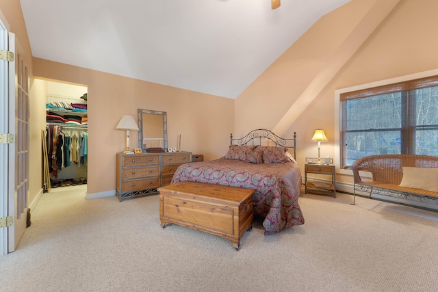 bedroom featuring ceiling fan, a spacious closet, light colored carpet, vaulted ceiling, and a closet