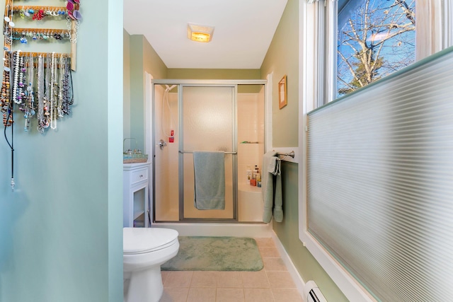 bathroom featuring tile patterned floors, vanity, toilet, and a shower with door