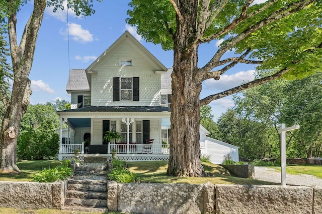 view of front of property featuring covered porch and a front lawn