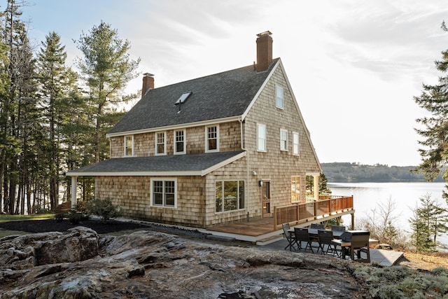 view of home's exterior featuring a deck with water view