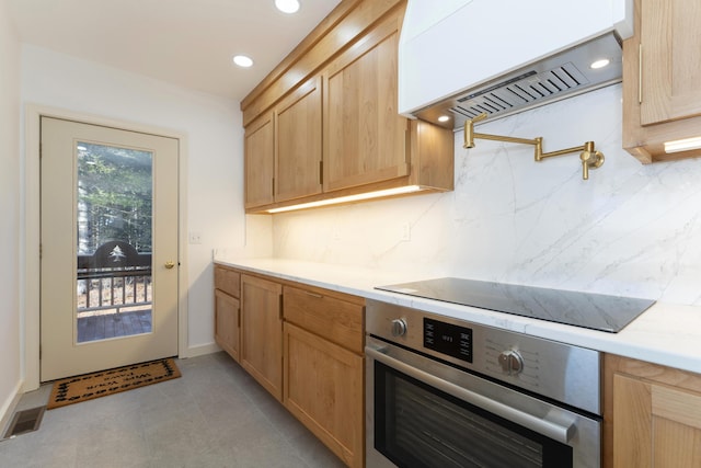 kitchen with stainless steel oven, light brown cabinets, backsplash, black electric cooktop, and custom exhaust hood