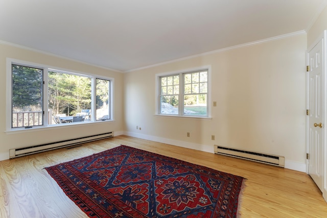 empty room with ornamental molding, light wood-type flooring, and a baseboard heating unit