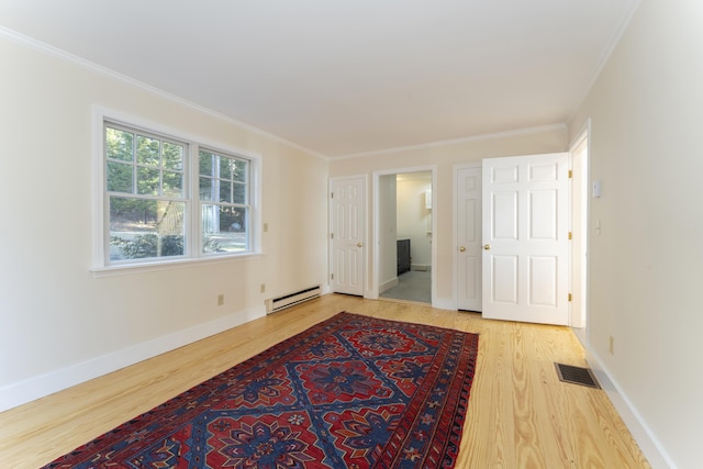 empty room featuring wood-type flooring, ornamental molding, and a baseboard radiator