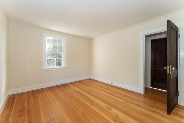 spare room with hardwood / wood-style floors and crown molding