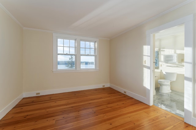 empty room featuring ornamental molding and light hardwood / wood-style flooring