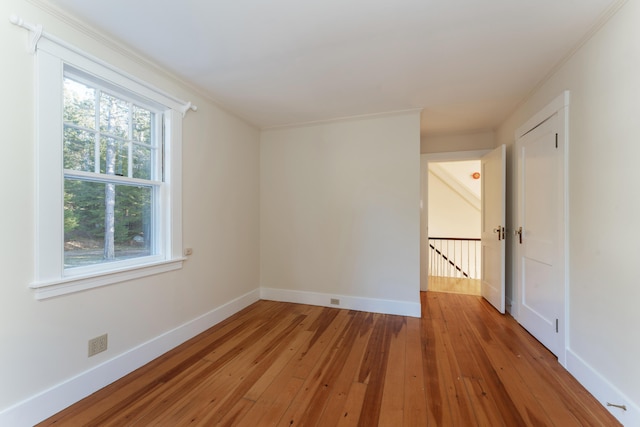 empty room featuring hardwood / wood-style flooring and crown molding