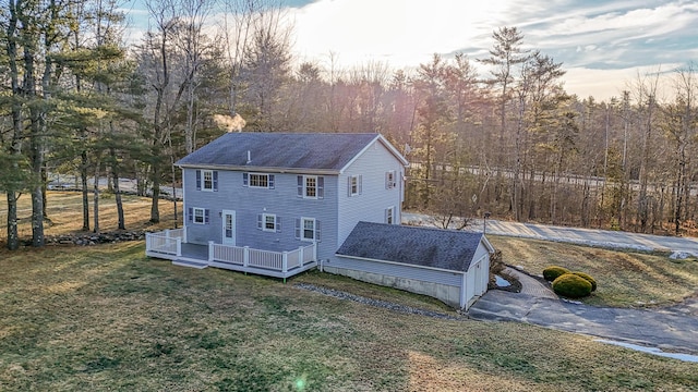 back house at dusk with a yard and a wooden deck