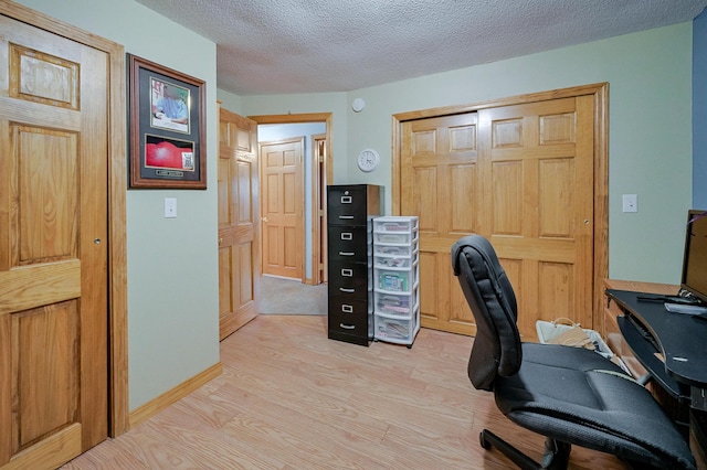 office space featuring a textured ceiling and light hardwood / wood-style flooring