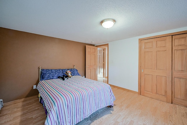 bedroom featuring wood-type flooring, a textured ceiling, and a closet