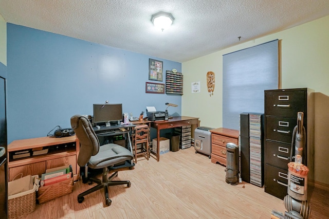 office area with light hardwood / wood-style floors and a textured ceiling