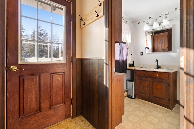 bathroom with a wealth of natural light, vanity, and wood walls