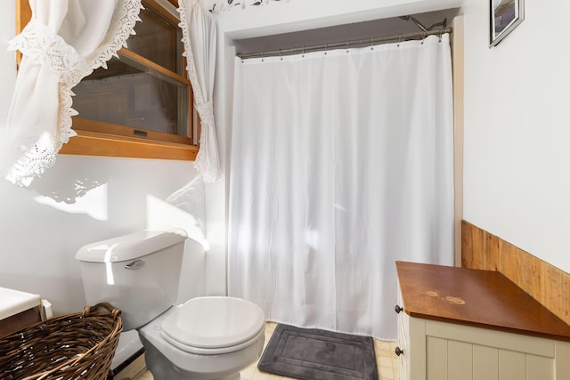 bathroom featuring wood walls and toilet