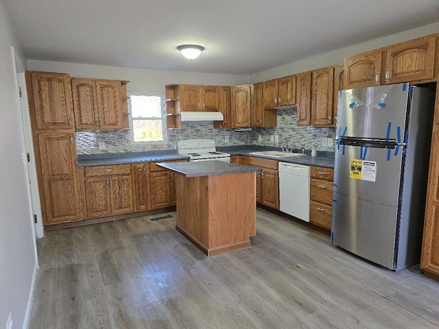 kitchen with a center island, white appliances, sink, and light hardwood / wood-style flooring