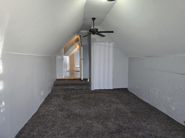 additional living space featuring ceiling fan, vaulted ceiling, and dark colored carpet