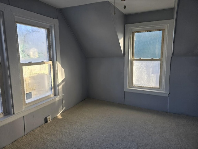 bonus room with carpet flooring and vaulted ceiling