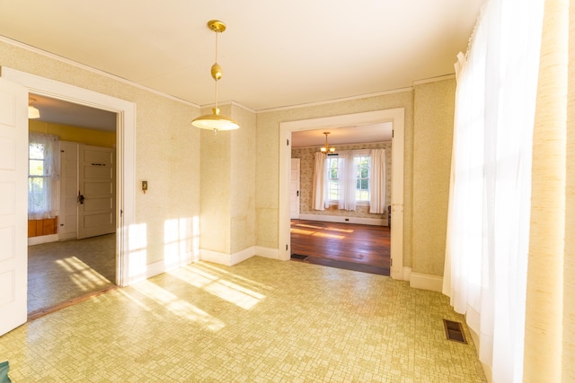 spare room with a chandelier and crown molding