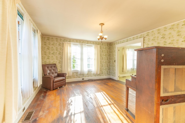 unfurnished room with a chandelier and hardwood / wood-style flooring