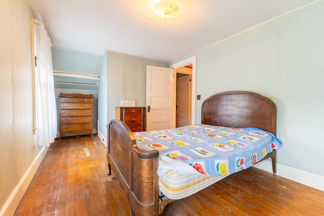 bedroom featuring wood-type flooring and ornamental molding