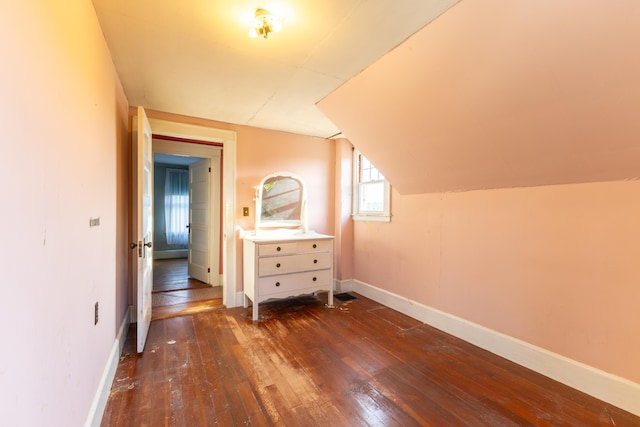 additional living space with dark wood-type flooring and vaulted ceiling