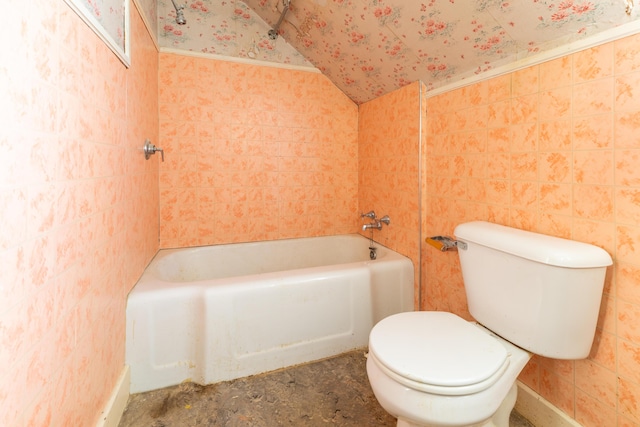 bathroom featuring a tub to relax in, vaulted ceiling, and toilet