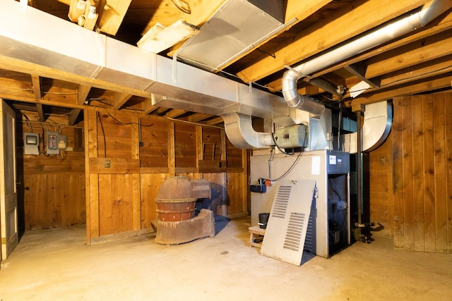 basement with heating unit and wooden walls